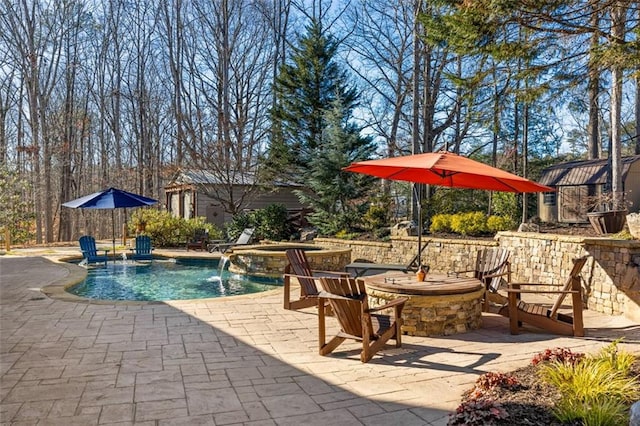 view of pool featuring an in ground hot tub, pool water feature, and a patio