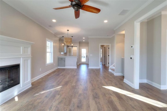 unfurnished living room with crown molding, wood-type flooring, and ceiling fan