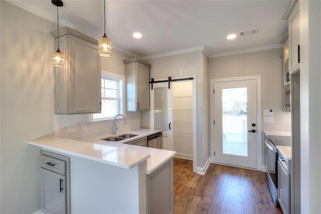 kitchen featuring sink, gray cabinetry, hanging light fixtures, kitchen peninsula, and a barn door