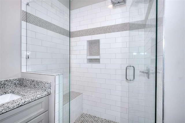 bathroom featuring walk in shower and vanity