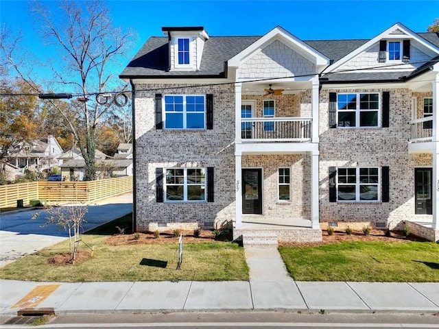 view of front of property with ceiling fan, a front yard, and a balcony