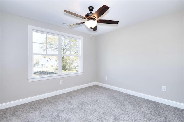 carpeted spare room with ceiling fan