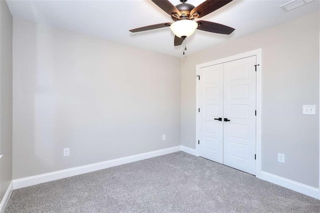 unfurnished bedroom with ceiling fan, carpet flooring, and a closet