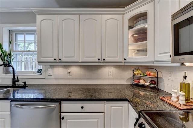 kitchen featuring a sink, stainless steel appliances, white cabinets, glass insert cabinets, and tasteful backsplash