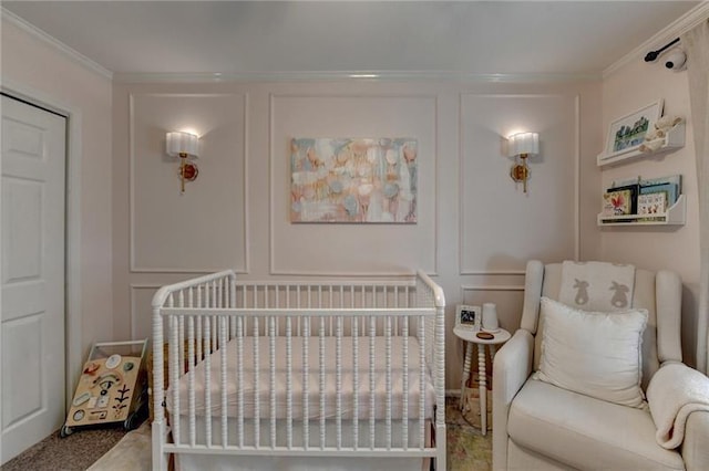 carpeted bedroom with a crib, a decorative wall, and ornamental molding