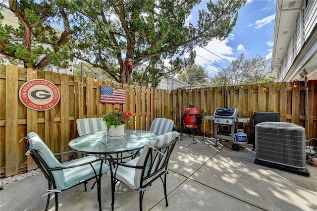 view of patio featuring outdoor dining space, area for grilling, central AC unit, and fence