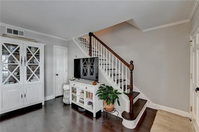 stairway with visible vents, crown molding, baseboards, and wood finished floors