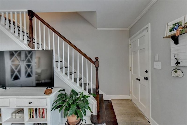 foyer entrance featuring stairs, wood finished floors, baseboards, and ornamental molding