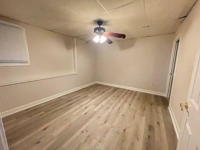 unfurnished room with light hardwood / wood-style floors, a drop ceiling, and ceiling fan