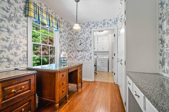 kitchen featuring pendant lighting, light stone countertops, washer / clothes dryer, and light hardwood / wood-style flooring