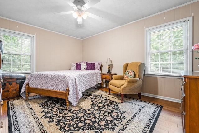 bedroom with hardwood / wood-style flooring, ceiling fan, and crown molding