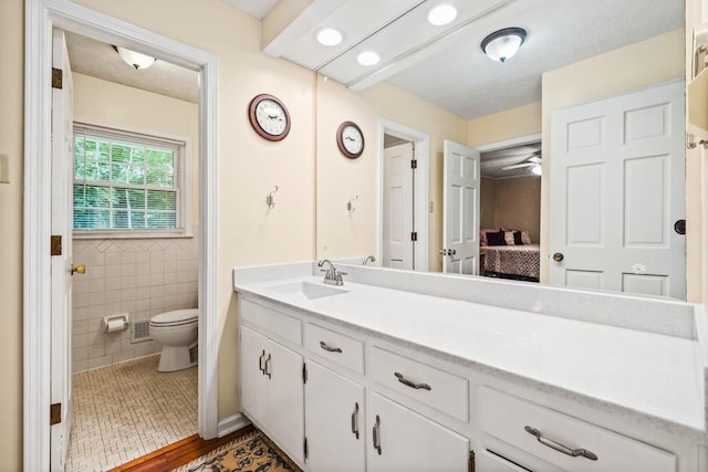 bathroom with vanity, ceiling fan, toilet, tile walls, and wood-type flooring