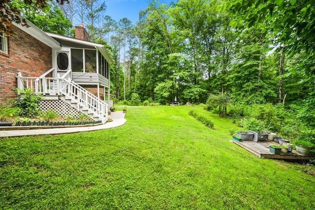 view of yard featuring a sunroom and a deck