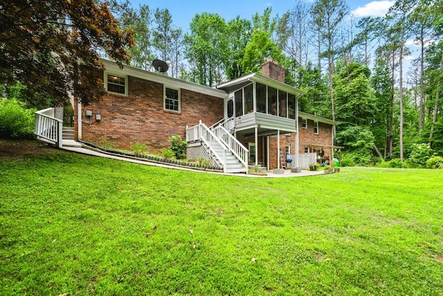 back of property featuring a sunroom and a lawn