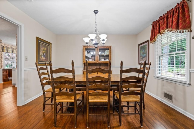 dining room with hardwood / wood-style floors and a chandelier