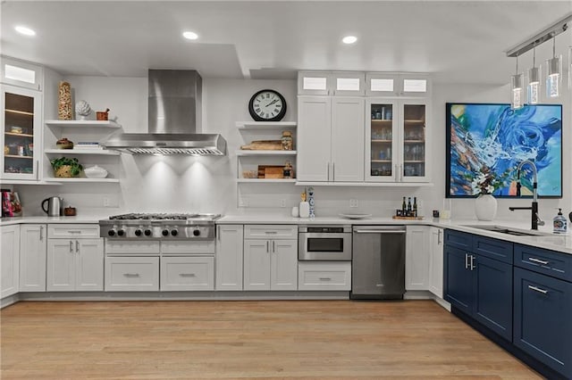 kitchen with open shelves, light countertops, appliances with stainless steel finishes, and wall chimney range hood