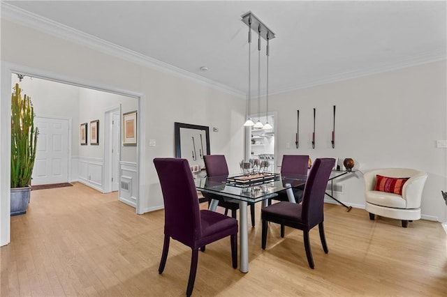 dining room featuring light wood-type flooring and ornamental molding