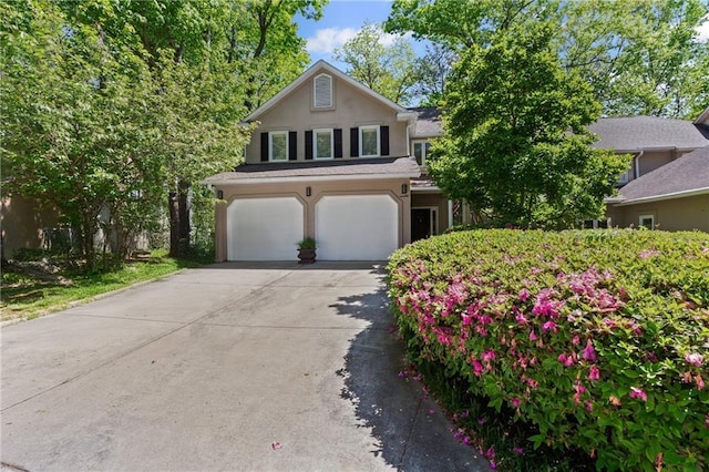 view of front facade featuring a garage, concrete driveway, and stucco siding