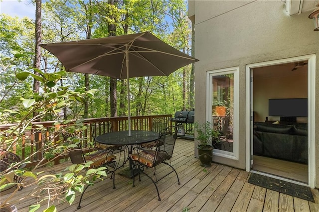 wooden deck featuring a grill and outdoor dining space