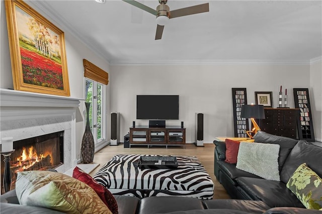 living area featuring ceiling fan, ornamental molding, wood finished floors, and a premium fireplace
