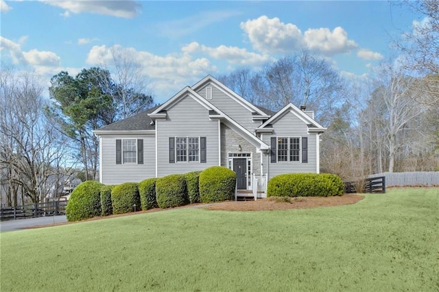 split foyer home featuring fence and a front yard