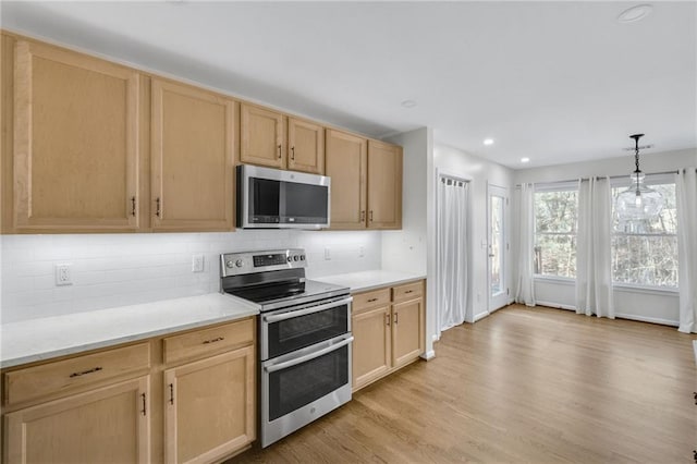 kitchen with light wood finished floors, decorative backsplash, appliances with stainless steel finishes, light brown cabinets, and recessed lighting