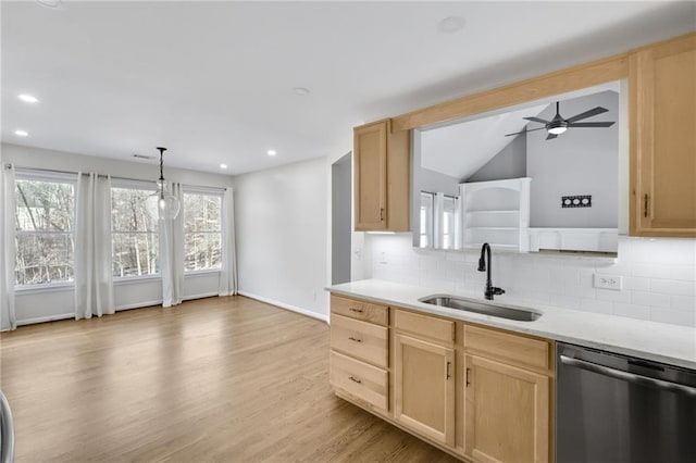 kitchen with light countertops, dishwasher, a sink, and light brown cabinetry