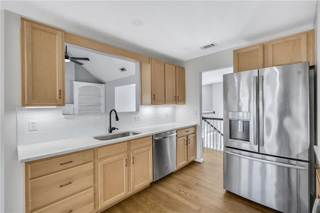 kitchen featuring appliances with stainless steel finishes, light brown cabinets, a sink, and visible vents