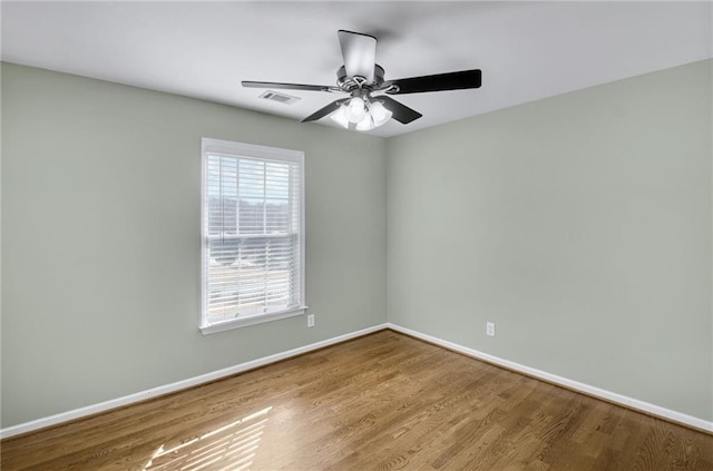 spare room with a ceiling fan, baseboards, and wood finished floors