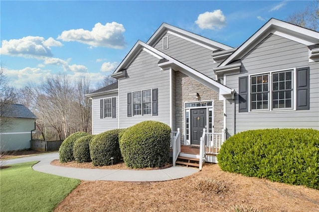 view of front of property with a front yard and stone siding