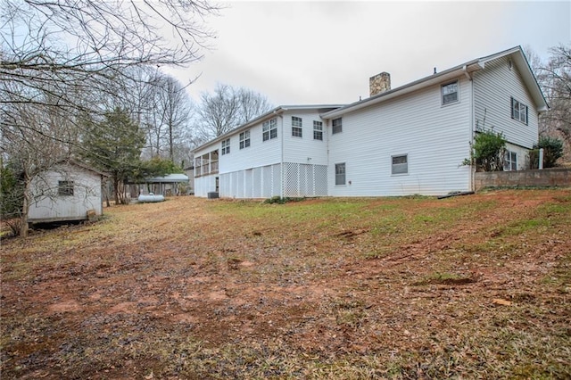 back of property with a storage shed