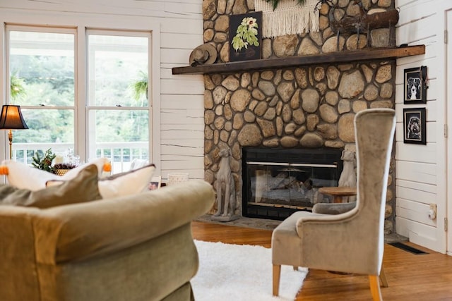 328 Black Ankle Creek Rd, Cherry Log, GA 30522 - living room featuring a stone fireplace, light hardwood / wood-style floors, and wood walls