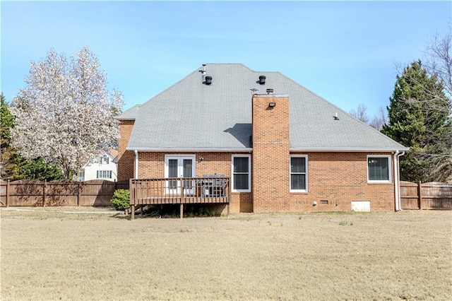 back of house featuring a deck, brick siding, a chimney, and a fenced backyard