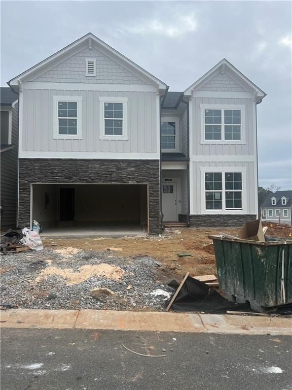 view of front of house with a garage, board and batten siding, and stone siding