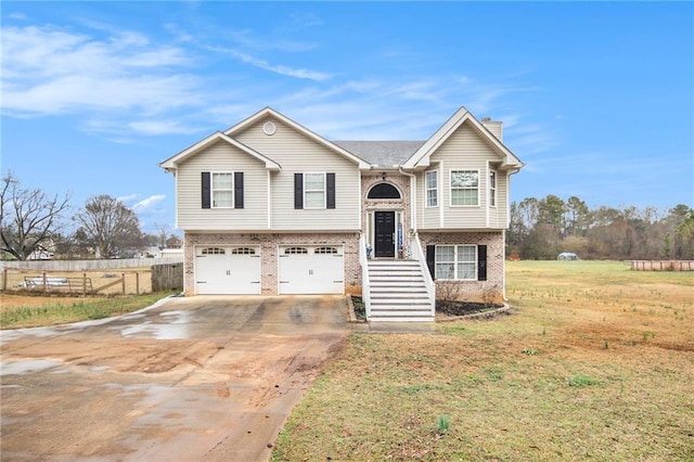 raised ranch featuring a garage and a front yard