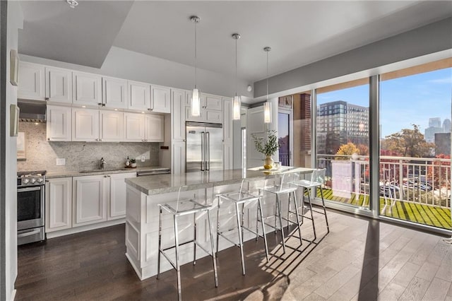 kitchen with a center island, dark wood-type flooring, decorative light fixtures, white cabinetry, and stainless steel appliances