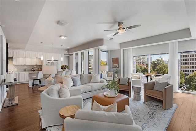 living room with dark hardwood / wood-style floors and ceiling fan