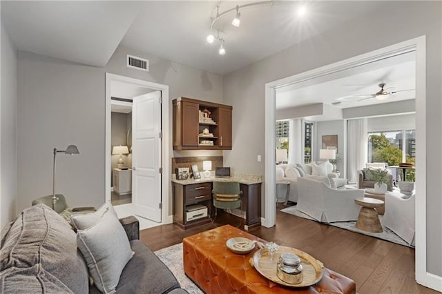 living room featuring ceiling fan and dark hardwood / wood-style flooring