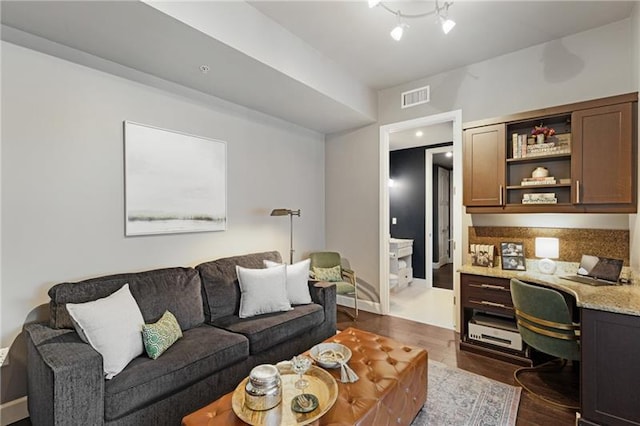 living room with dark hardwood / wood-style flooring and built in desk