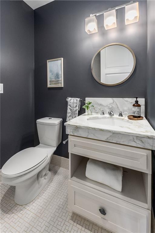 bathroom featuring tile patterned floors, vanity, and toilet