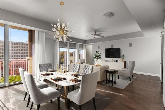 dining area featuring ceiling fan with notable chandelier and dark wood-type flooring