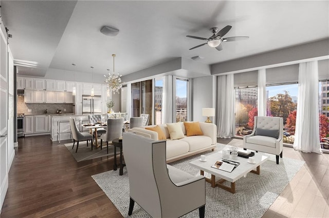 living room featuring dark hardwood / wood-style flooring, plenty of natural light, and ceiling fan with notable chandelier