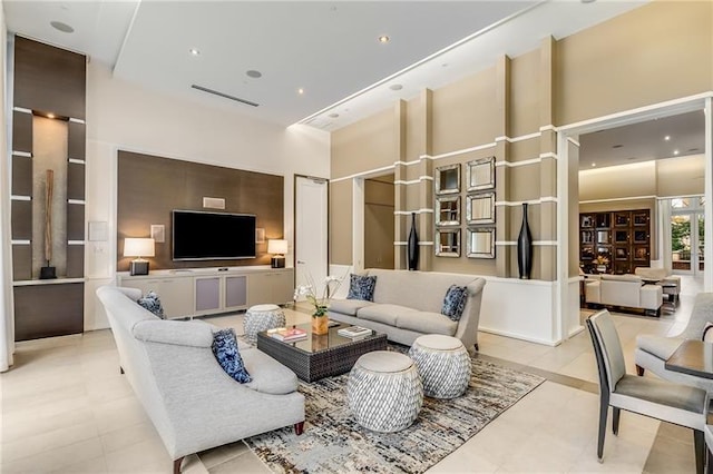 tiled living room featuring a towering ceiling