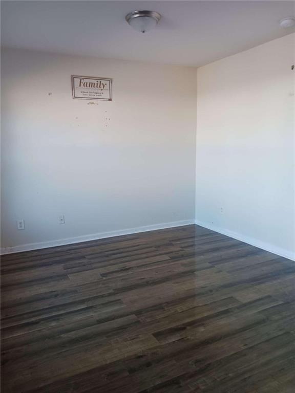 empty room with dark hardwood / wood-style floors