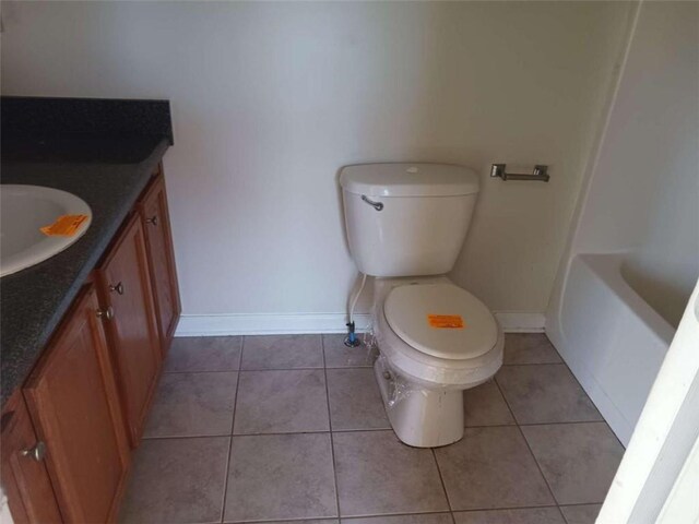 bathroom with tile flooring, vanity, and toilet