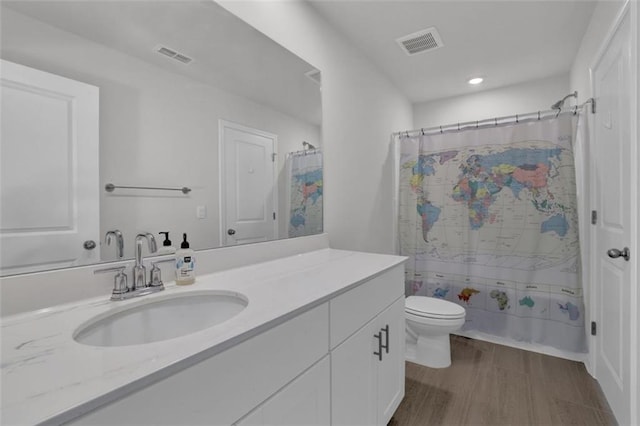 bathroom featuring toilet, hardwood / wood-style floors, and vanity