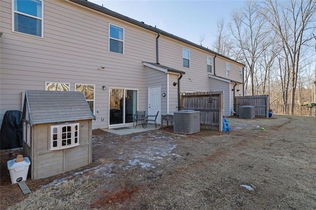 back of property featuring a storage shed and central air condition unit