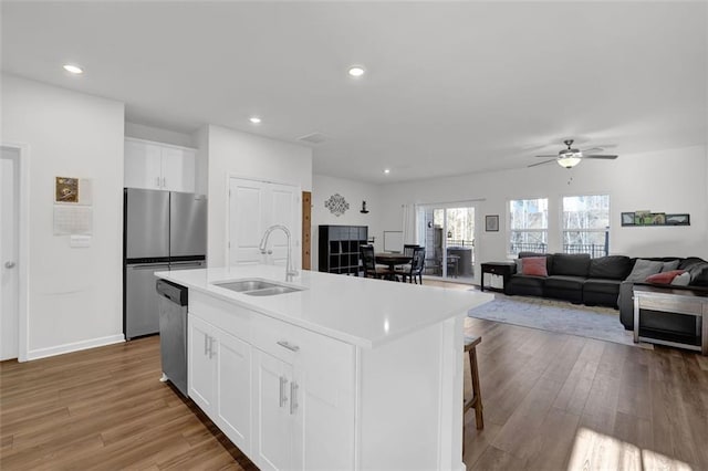 kitchen featuring white cabinetry, stainless steel appliances, sink, a kitchen island with sink, and ceiling fan