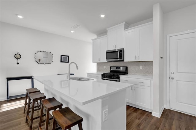 kitchen featuring white cabinetry, appliances with stainless steel finishes, a center island with sink, and sink