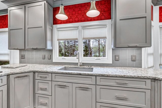 kitchen with backsplash, gray cabinets, and a sink